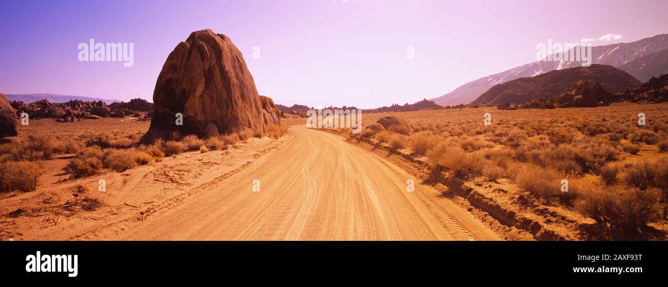 Die schmutzige Straße führt durch eine aride Landschaft, die kalifornische Sierra Nevada, Kalifornien, USA Stockfoto
