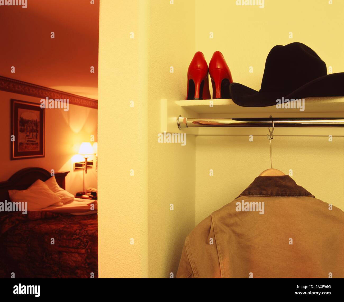 Nahaufnahme einer Jacke und eines Cowboyhuts mit einem Paar Schuhen mit hohem Absatz in einem Regal eines Motelzimmers, Kalifornien, USA Stockfoto