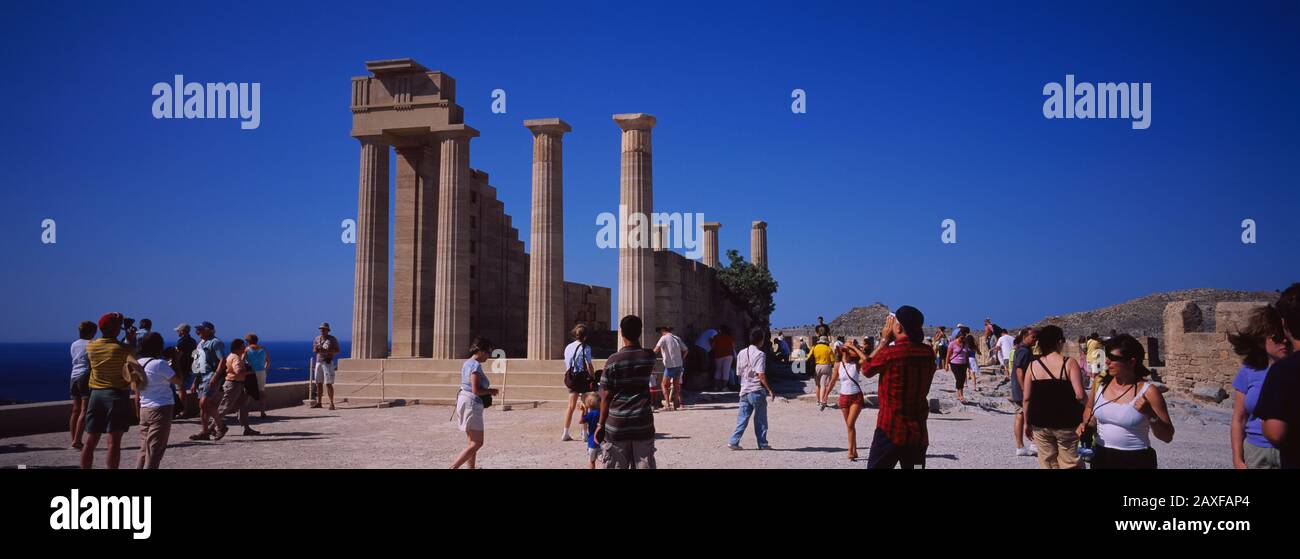 Touristen vor den alten Ruinen eines Tempels, Tempel Der Athena Lindia, Akropolis, Lindos, Rhodos, Griechenland Stockfoto