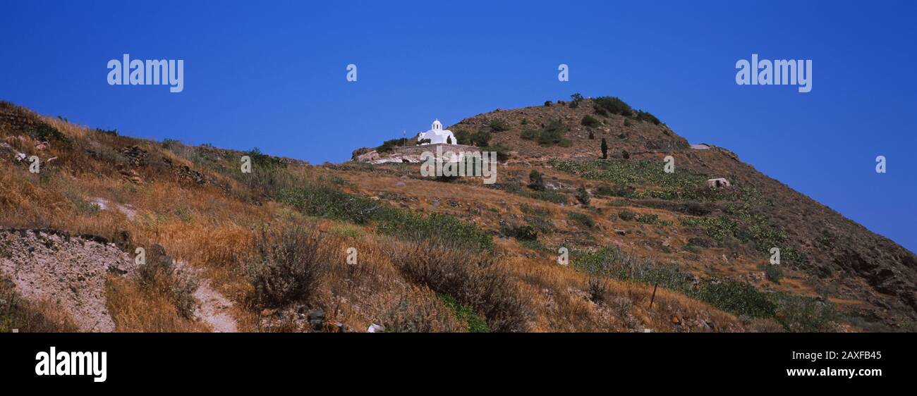 Niedriger Blick auf eine Kapelle auf einem Hügel, auf dem Weg nach Oia, Santorini, Griechenland Stockfoto