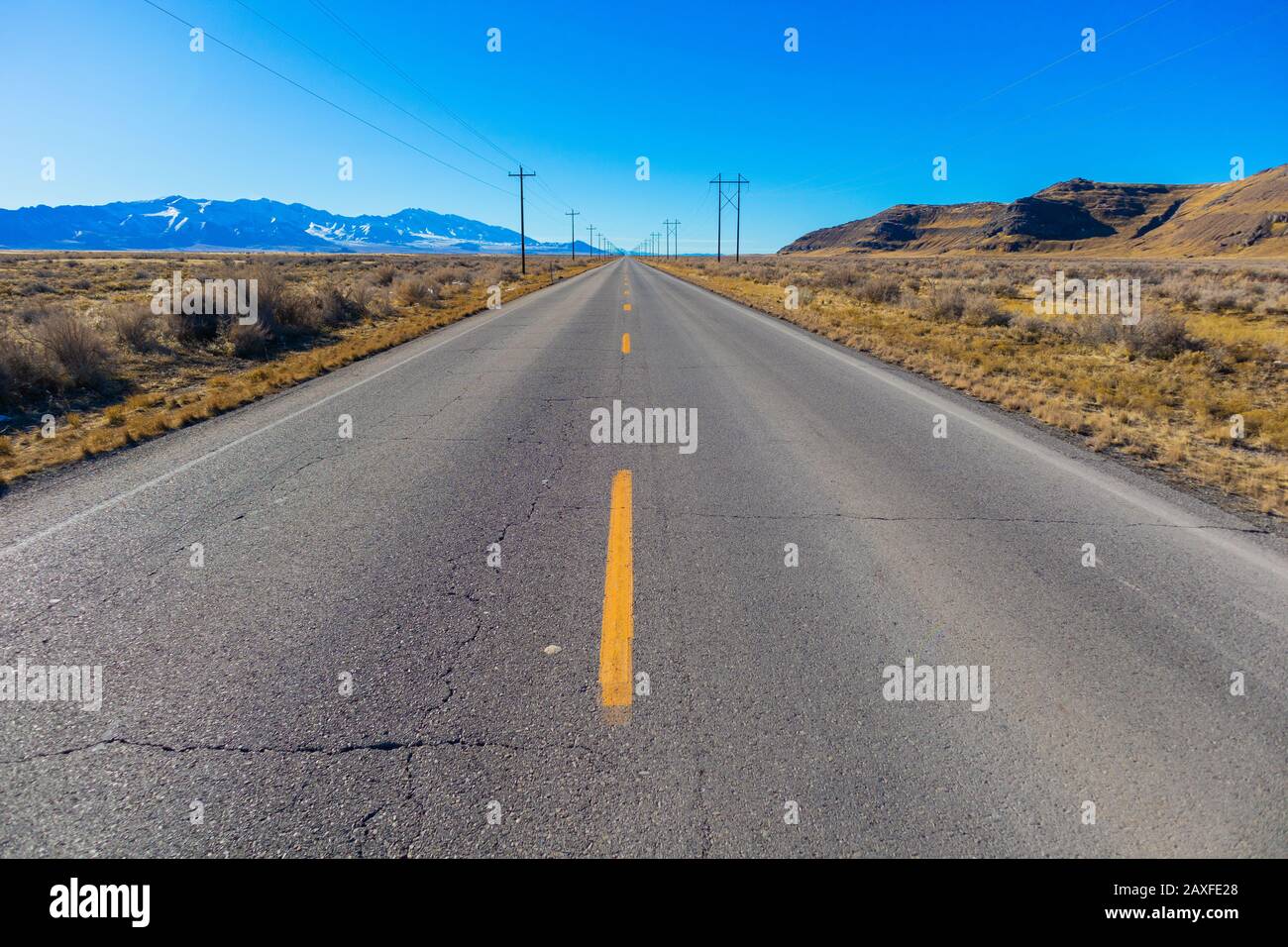 Landstraße mit Stromleitungen Stockfoto