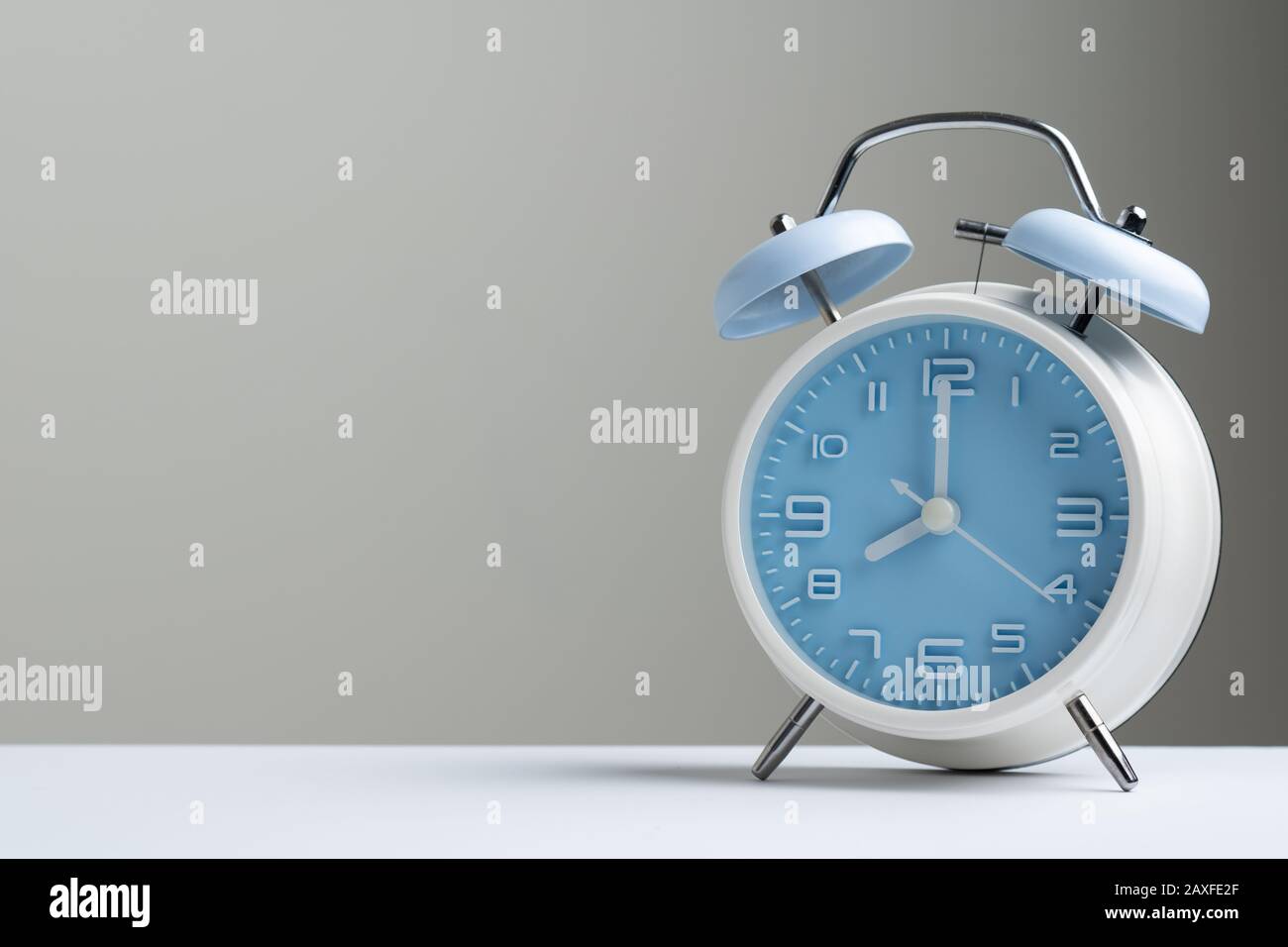 Blau-farbiger, altmodischer Wecker mit 8-Uhr-Anzeige, isoliert auf weißem Hintergrund Stockfoto