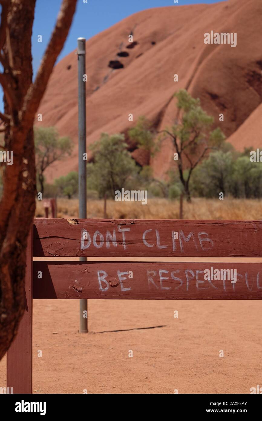 Uluru-Schild - klettern Sie nicht respektvoll; graffiert auf der Rückseite eines Schildes. Besteigen Sie den Parkplatz, Uluru-Kata Tjuta Nationalpark, Northern Territory's Stockfoto