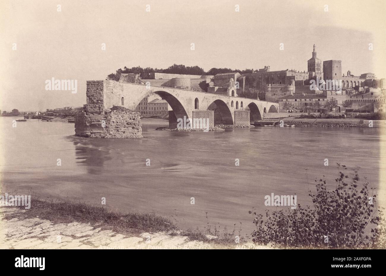 1890 Ca, AVIGNON, Provence-Alpen-Cote d'Azur, FRANKREICH: Blick über die Rhone nach Nordosten mit dem Pont Saint Benezet oder dem Pont d'Avignon. Das SCHLOSS DER PÄPSTE und die KATHEDRALE im Hintergrund ( Bischofsensemble ). FOTO VON ND - PAPSTPALAST - FOTO STORICHE - GESCHICHTSFOTOS - BESTAND - GEOGRAFIA - GEOGRAPHIE - ARCHITEKTUR - ARCHITETTURA - VECCHIA EUROPA - ALTES EUROPA - FRANCIA - PALAZZO DEI PAPI - PAPA - CATTEDRALE - CHIESA - KIRCHE - PROVENZA - PONTE - FIUME - FLUSS - RODANO © Archivio GBB / Stockfoto