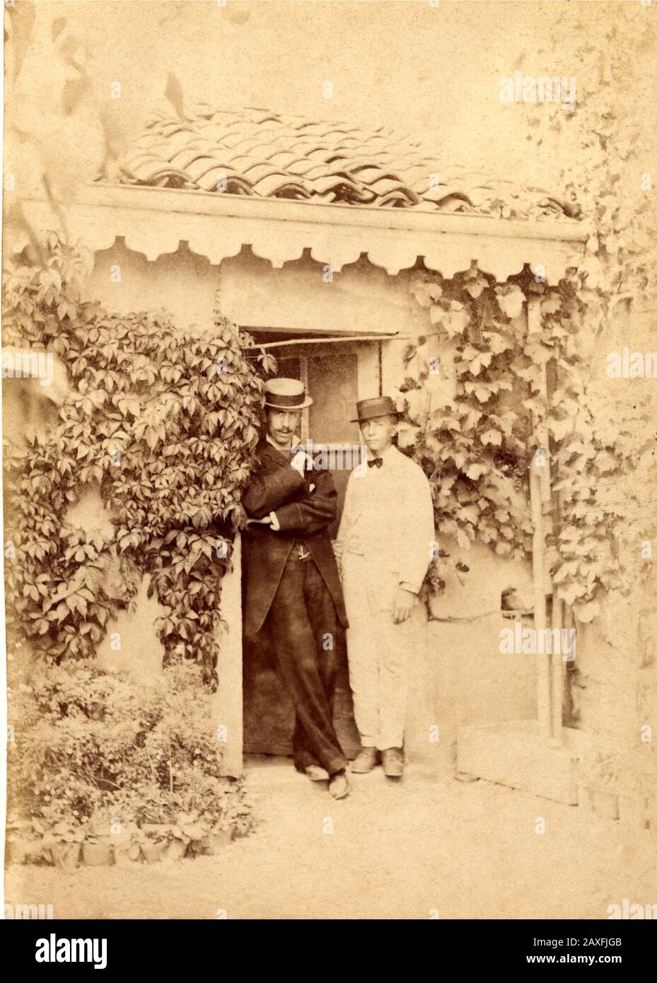 1890 Ca, ITALIEN: EIN paar Touristen (auf Capri oder Taormina) - ITALIEN - FOTO STORICHE - GESCHICHTE - GEOGRAFIA - GEOGRAFIE - TURISTI - TURISMO - TURISMUS - Villeggianti - VACANZE ESTIVE - SOMMERHOLYDAYS - ANWESEN - Reise - Garten - Giardino - Vita quotidiana - BELLE EPOQUE - Hut - cappello - plieta - Krawatte Bogen - papillon - cravatta - DANDY - weißes Kleid - abito vestito bianco - HOMOSEXUELL - omosessuale - omosessualita' - coppia di uomini - maschile - Paar Männer - Homosexualität © Archivio GBB / Stockfoto
