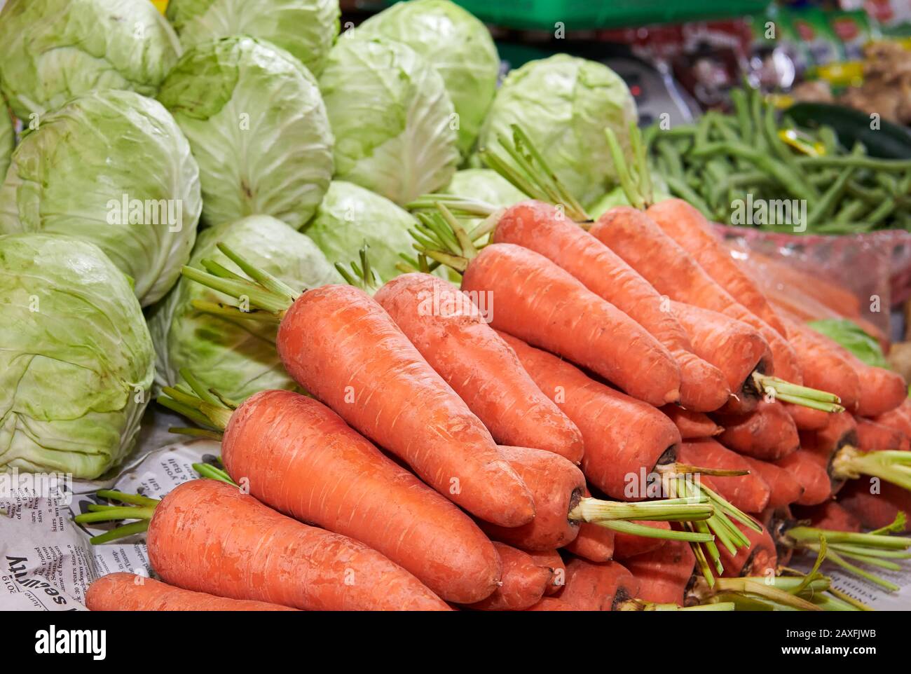 Nahaufnahme verschiedener frisch reifer Gemüsesorten wie Karotten, Bohnen und Kohlkohl auf einem nassen Markt in Iloilo, Philippinen, Asien Stockfoto