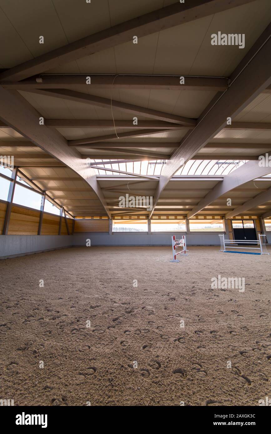 Eine aufwendige Dachkonstruktion bedeckt eine neu erbaute, mit Sandboden gefüllte Riesen-Reitarena Stockfoto