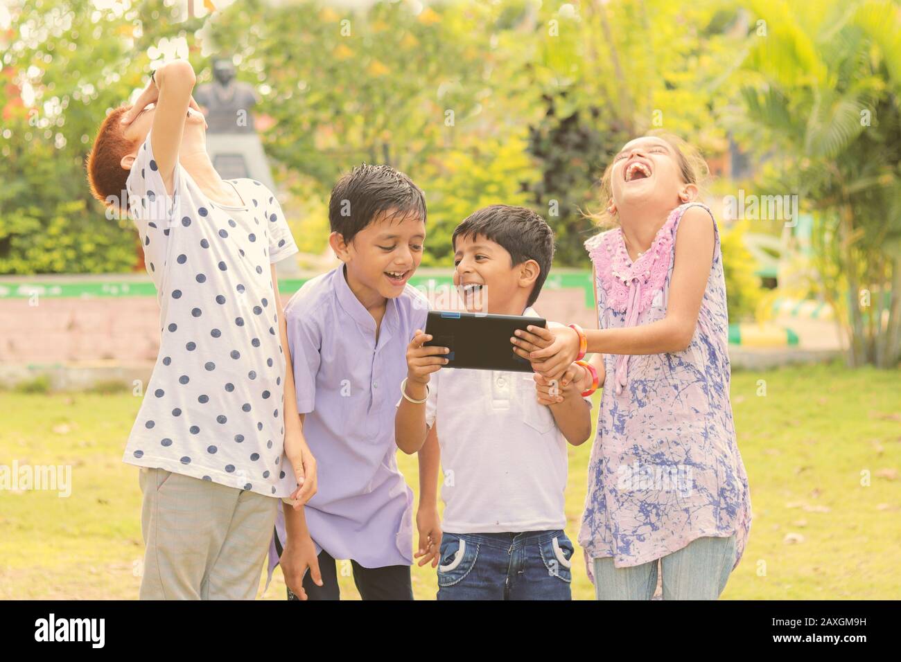 Gruppe Von Kindern lachen, indem sie Medien auf dem Handy sehen - Kinder, die Spaß haben, indem sie auf Smartphone schauen - Konzept von Teenagern, die abhängig sind von Handys und Stockfoto