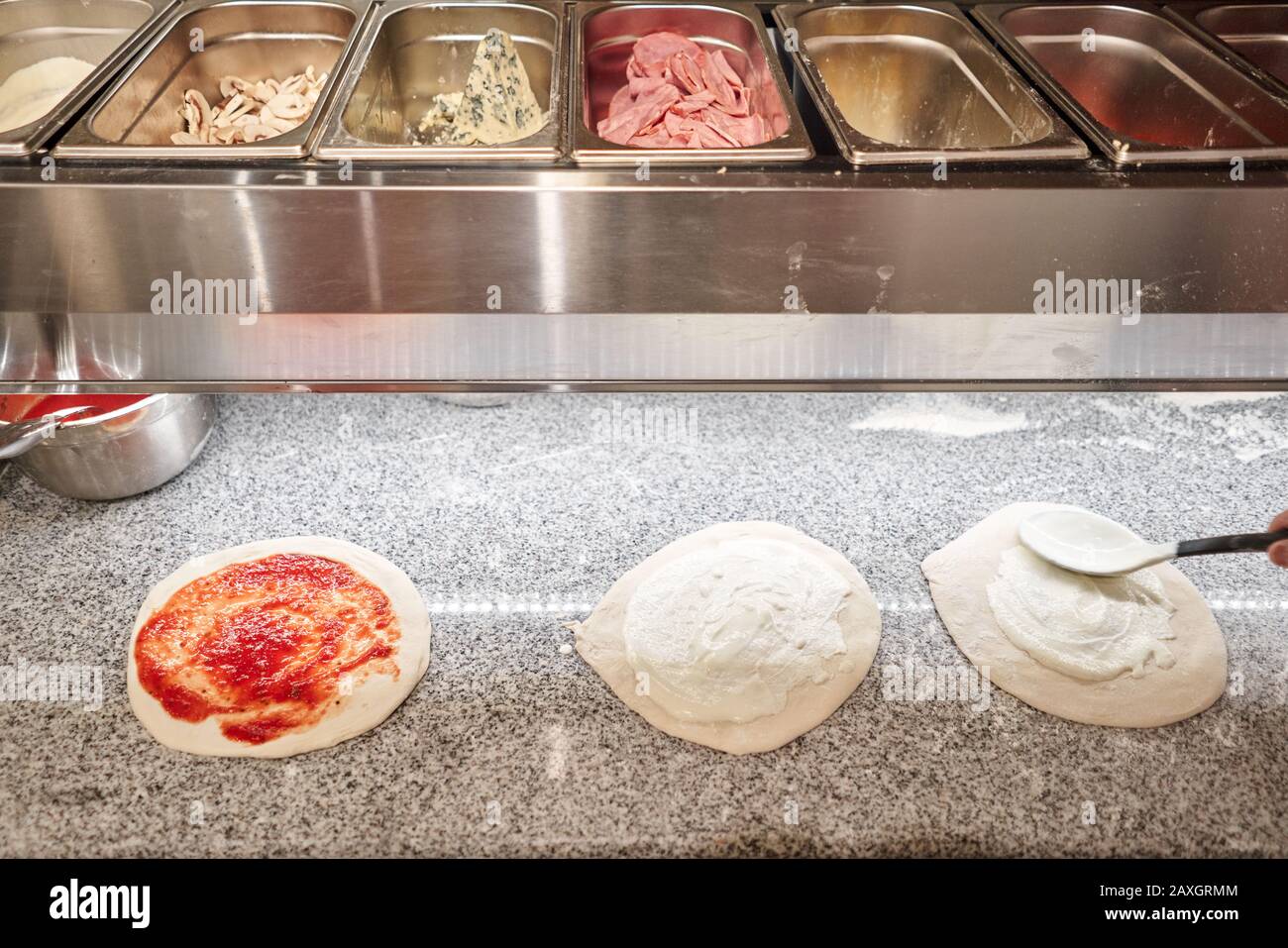 Halbfertige Produkte zum Kochen von Pizza in kalten Tisch für Rohlinge füllen. Traditioneller Holzofen im Restaurant, Italien. Originale neapolitanische Pizza. Rot Stockfoto