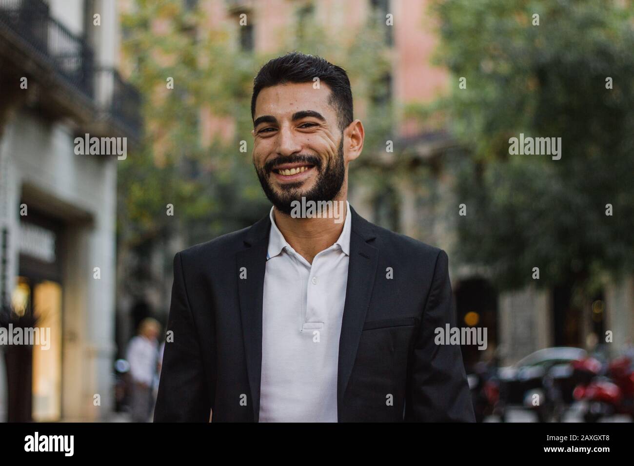 Gutaussehender arabischer Kerl lächelt. Erfolgreicher Mann, der auf der Straße spazieren ging Stockfoto