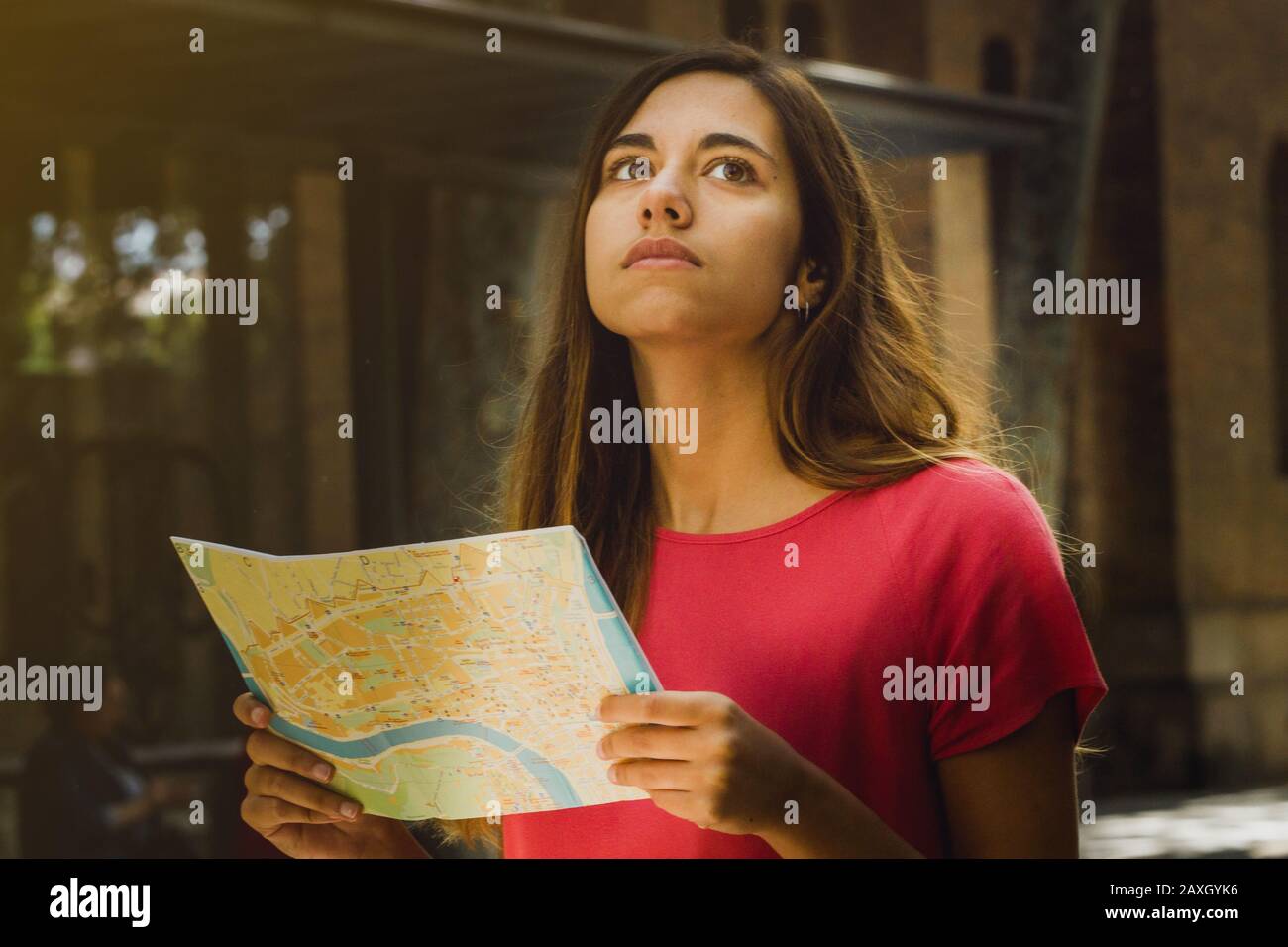 Touristin sucht in einer Stadtkarte nach einem Ort im urbanen Hintergrund. Junge Reisende erasmus-studentin verloren Stockfoto
