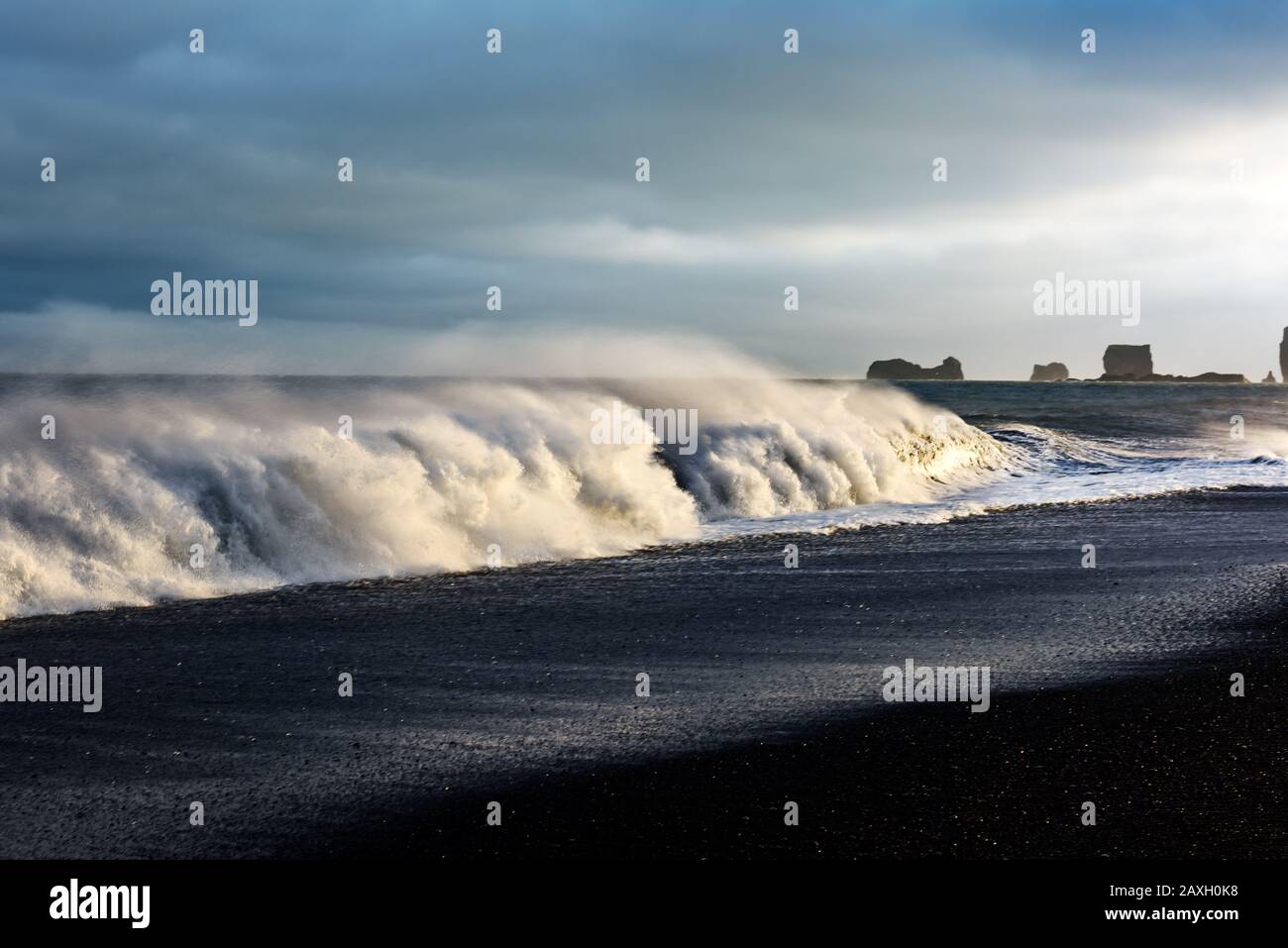 Wunderschöne Landschaft mit großen Wellen am Schwarzen Strand. Stürmische Wellen des Atlantiks und eine Wolkenlandschaft. Reynisdrangar, Vik, Island Stockfoto