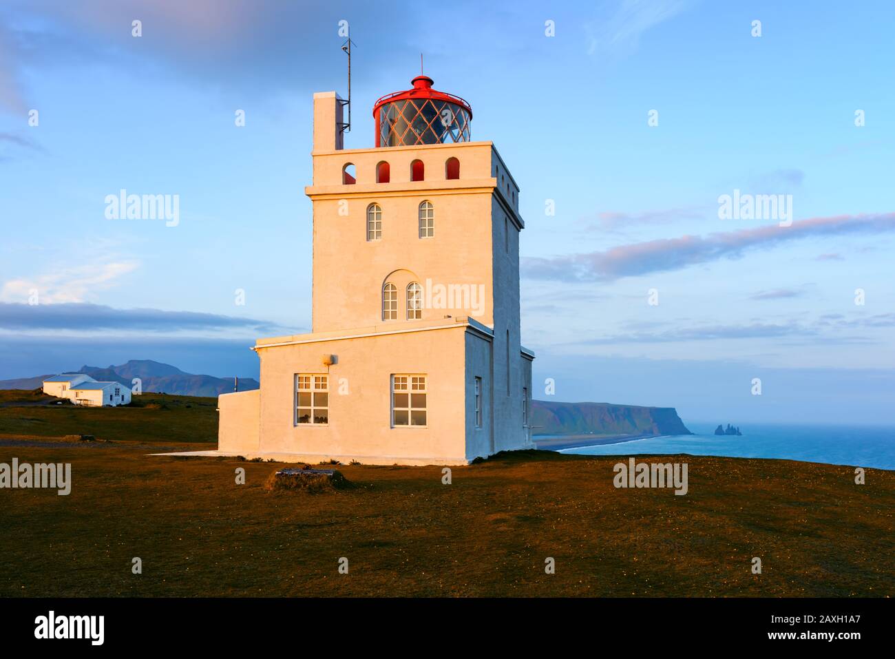 Wunderschöne Landschaft mit weißem Leuchtturm am Kap Dyrholaey, an der Südküste des Atlantiks in Island Stockfoto