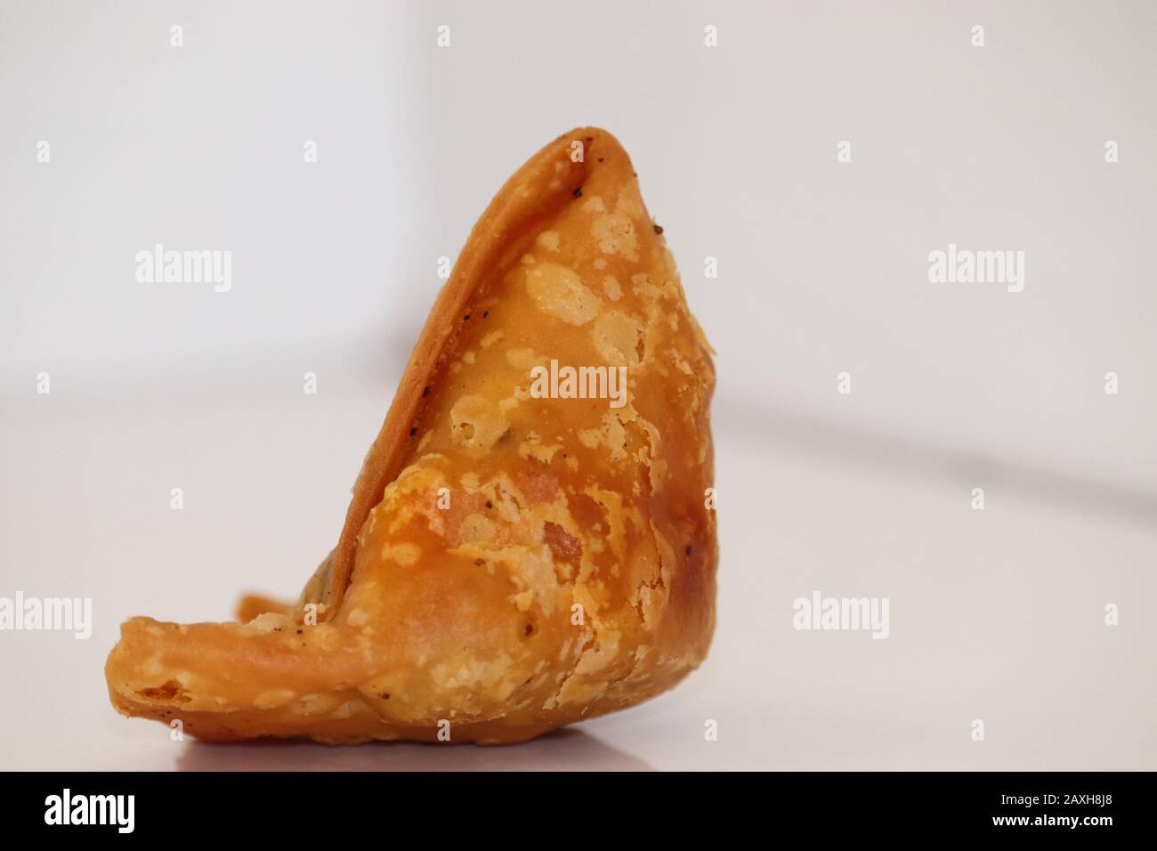 Weißer Hintergrund mit vegetarischen Kartoffelsamosen oder Samosas. Indische Spezial-Straßennahrung. Berühmte indische Küche Samosa gefüllt mit Kartoffelmischung, gab es auf der Insel Stockfoto