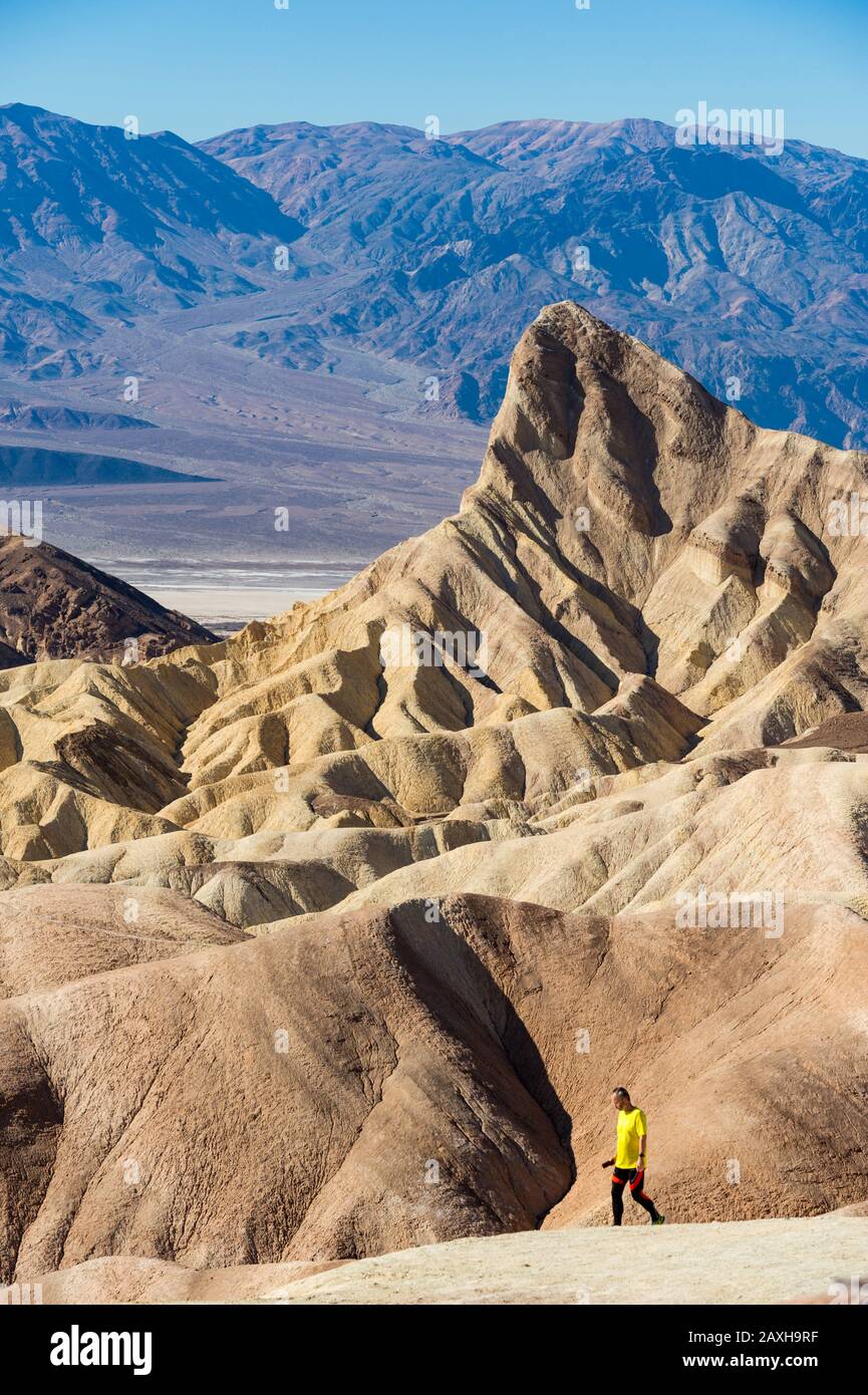 Vereinigte Staaten, Kalifornien: Zabriskie Point, Teil der Amargosa Range, östlich von Tod Valley und Manly Beacon. Mann, Tourist, zu Fuß in die sa Stockfoto