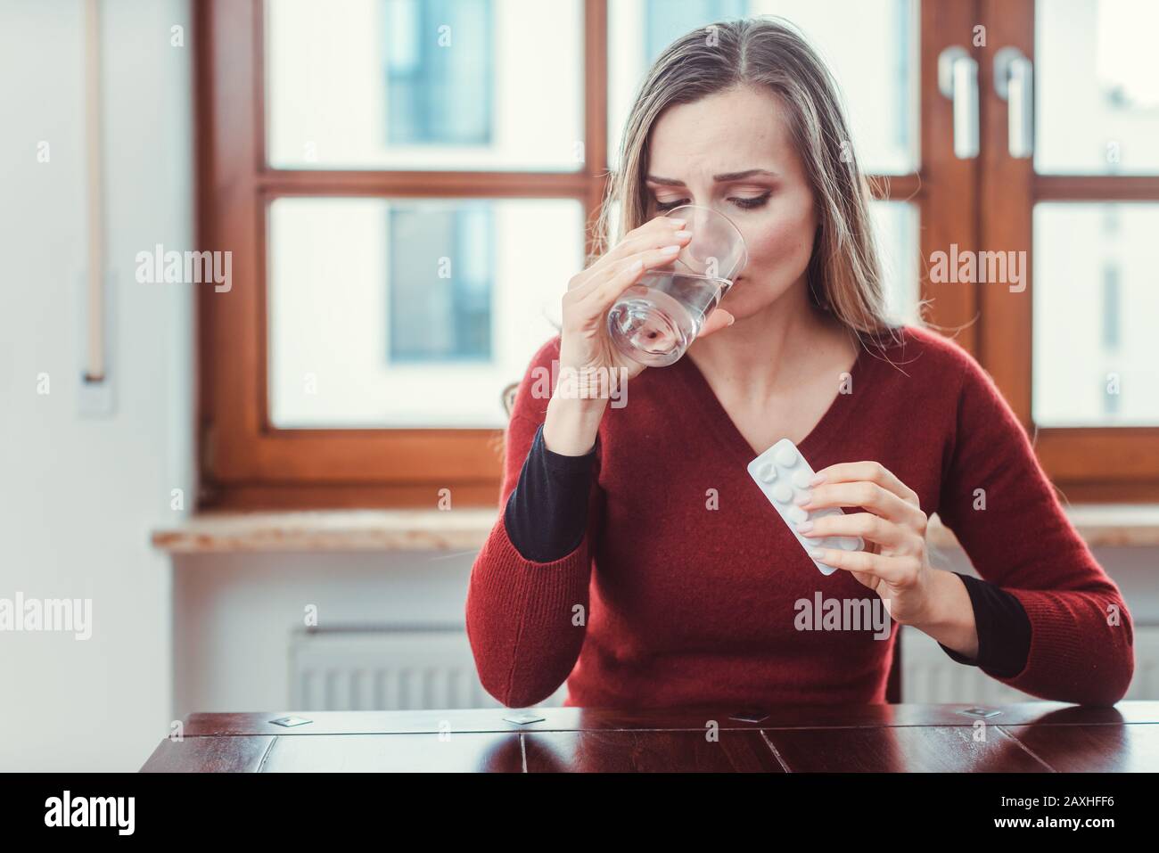 Frau, die sich krank oder unwohl fühlt und Medikamente nimmt Stockfoto