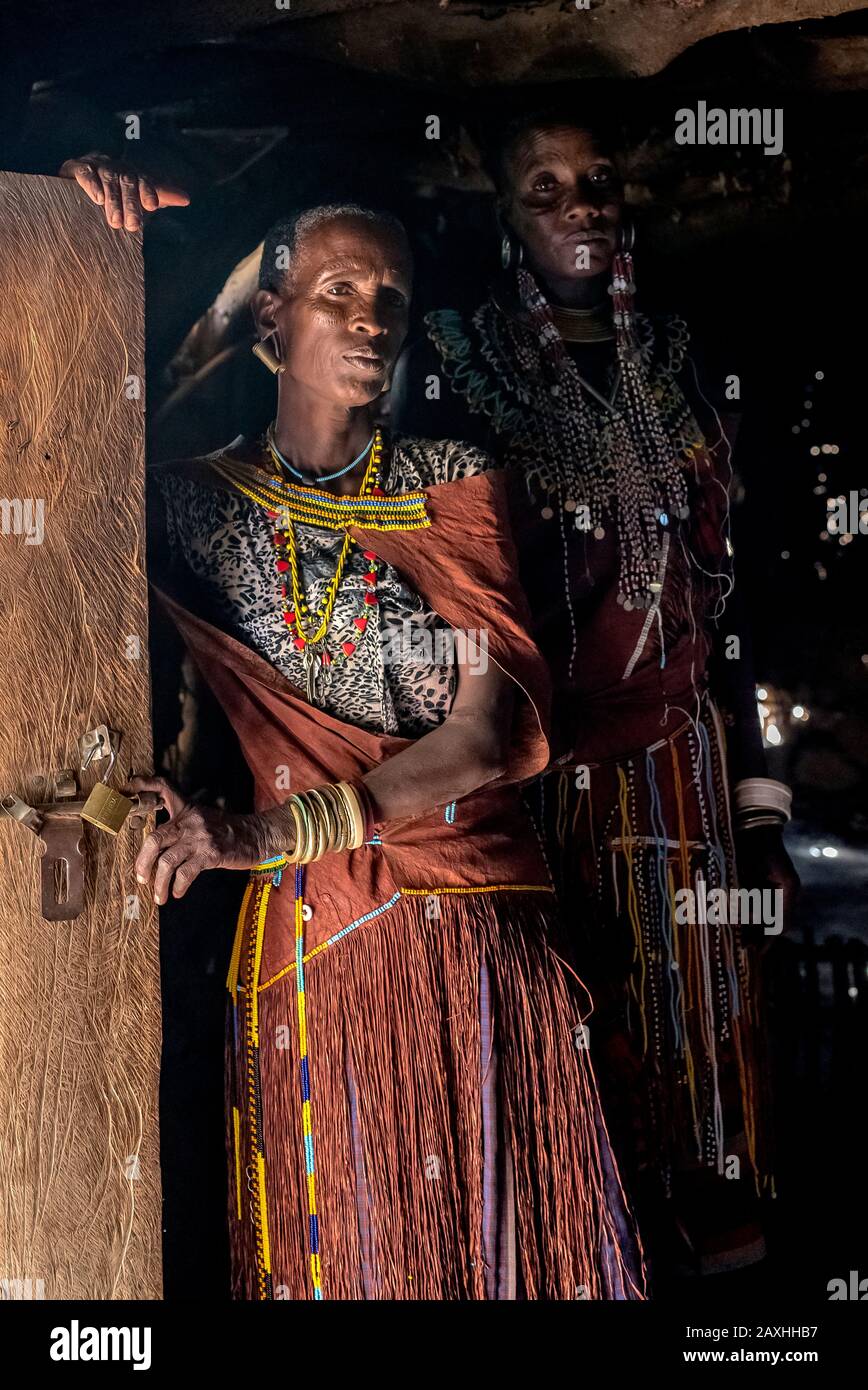 Tätowierte afrikanische Frau in Gedanken verloren. Aufgenommen während eines Besuchs in einem lokalen Boma in der Nähe des Lake Eyasi. Stockfoto