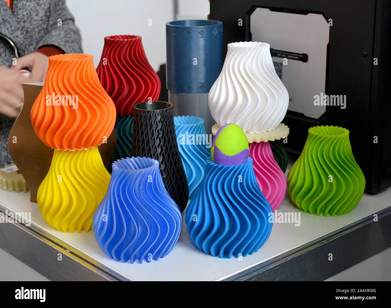 Produktion wird von 3D-Drucker auf Tischnähe gedruckt. Verschiedene Farbenfrohe Objekte, die auf einem 3D-Drucker auf einem Tisch gedruckt werden Stockfoto