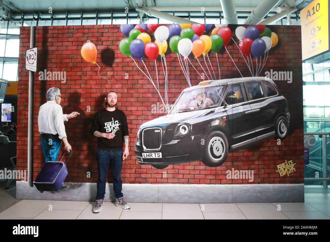 Der Künstler Rogue One aus Glasgow rekonstruiert ???Floating Taxi???, eines der meistfotografierten Street Art-Stücke der Welt, in Heathrow als Teil des Flughafens???s Angebot, das am meisten ???Instagrammed???? flughafen in der Welt. Stockfoto