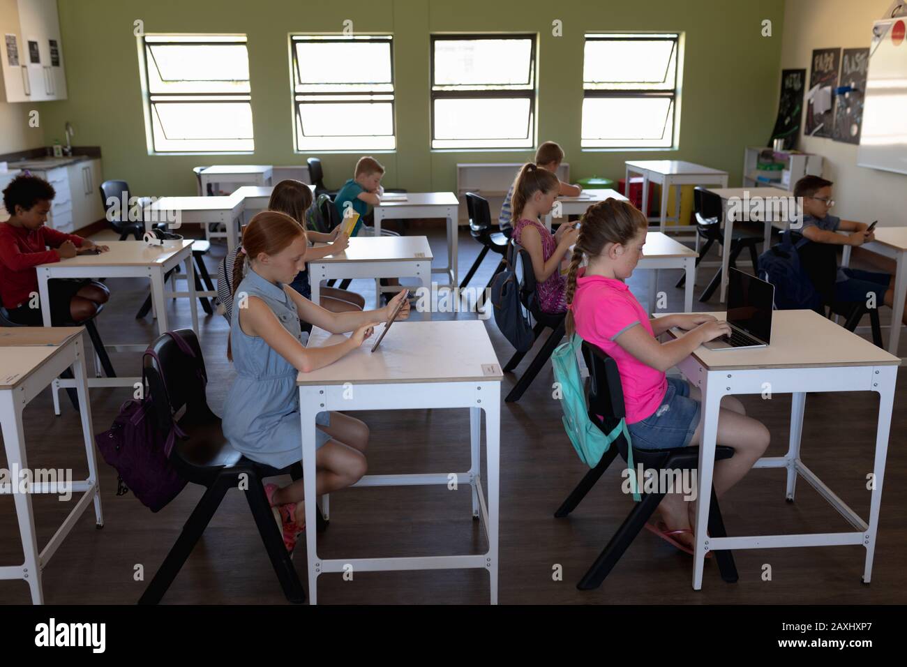 Seitenansicht einer vielfältigen Gruppe von Schulkindern konzentrierte sich auf das Sitzen an Schreibtischen und die Verwendung von Personal Computern in einem Schulunterricht Stockfoto