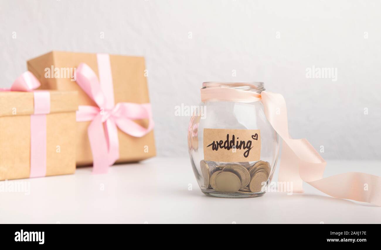 Geldmünzen in Glasbecher mit Text für Hochzeit Stockfoto