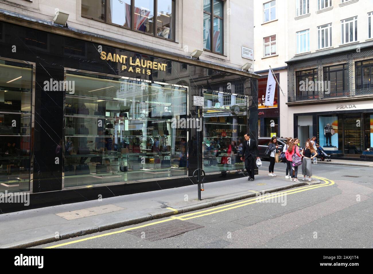 London, Großbritannien - 9. JULI 2016: Menschen gehen am Saint Laurent Modeshop in Mayfair, London. Mayfair ist ein großes Einkaufsviertel im Londoner West End. Stockfoto