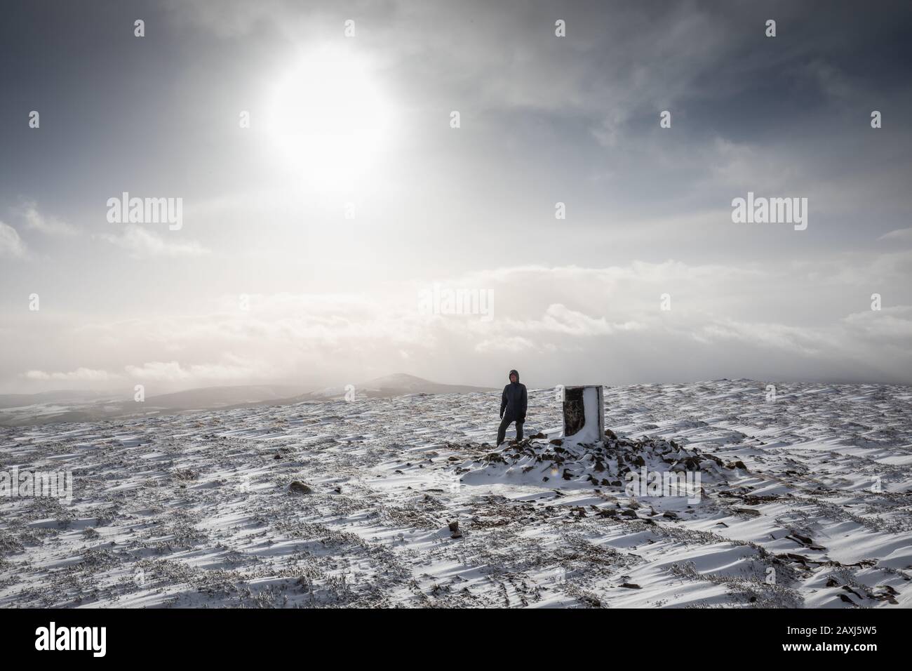 Ein Wanderer auf dem schneebedeckten Gipfel von Ben Aigan, einem 471 Meter hohen Hügel zwischen Craigellachie und Keith in Speyside, Schottland, Großbritannien Stockfoto