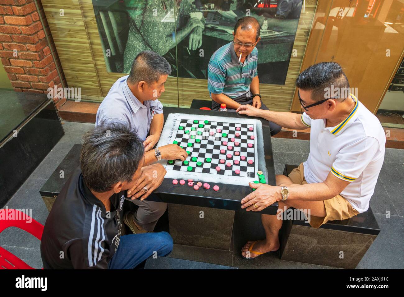 Lokale chinesische Männer spielen die lokalen und beliebten Checker aus Singapur in einer Hinterstraße von Chinatown, Singapur, Asien Stockfoto
