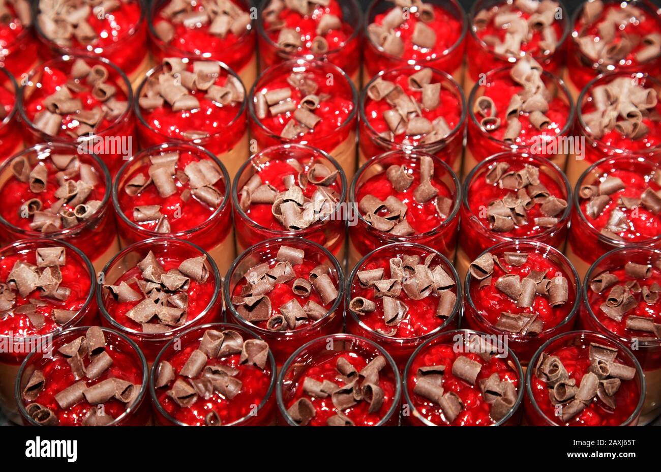 Mini-Desserts mit roter Mousse in kleinen Gläsern, mit Schokolade bestreut Stockfoto