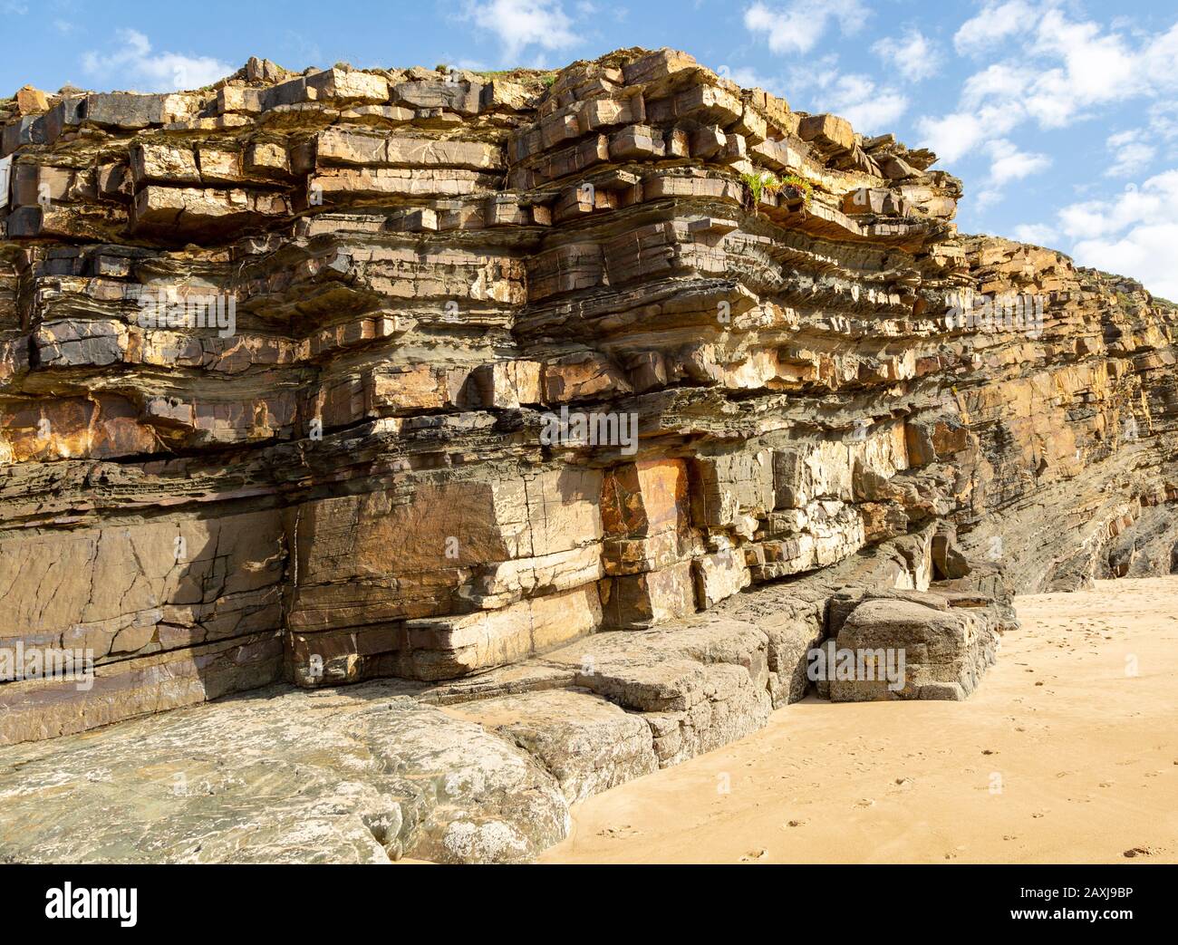 Geneigte Schichten, die Bettwäscheflugzeuge zeigen, wie die sedimentären Felsklippen an der Küste von Odeceixe, Algarve, Portugal und Südeuropa. Differentielle Erosion Stockfoto