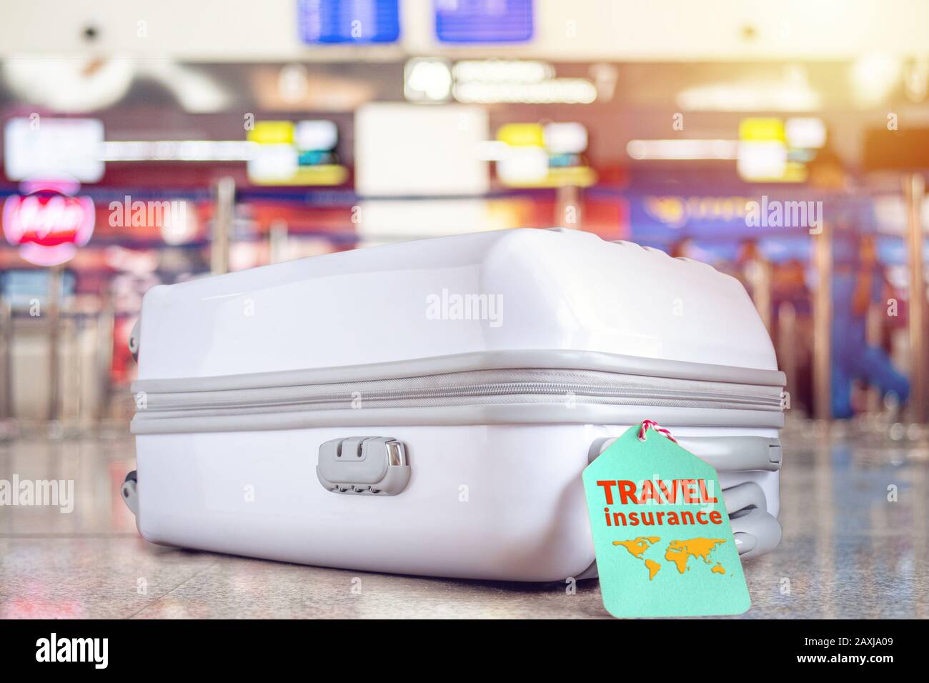 Reisetasche am Flughafen mit Reiseversicherungsschild auf dem Kofferhalter für Verspätung oder verlorenes Gepäck, Stornierung von Reisen, Unfall, Verluste usw. an pr Stockfoto