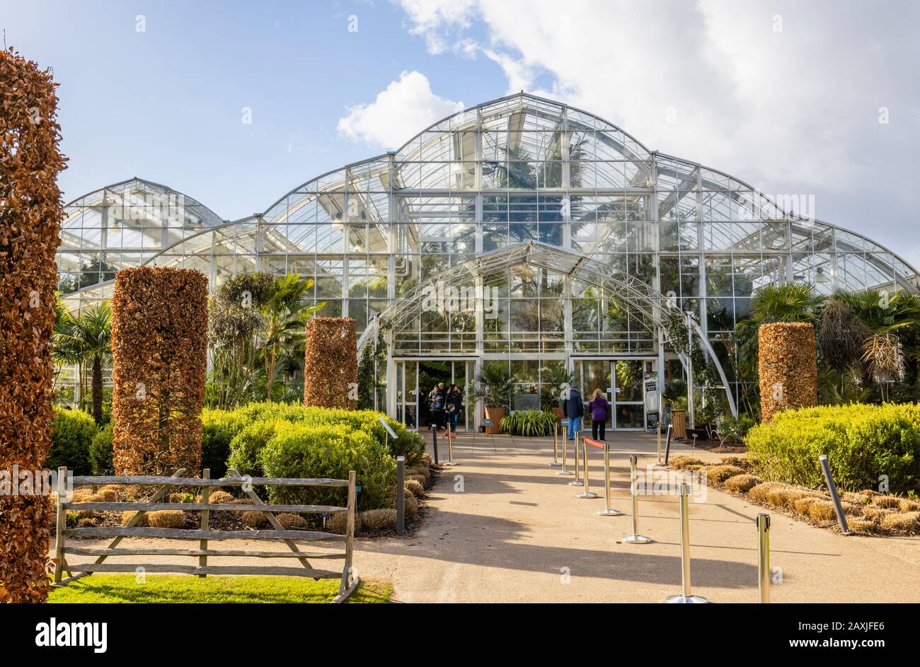 Eingang zum Glasshouse in RHS Gardens, Wisley, Surrey, Südostengland an einem sonnigen Wintertag mit blauem Himmel Stockfoto