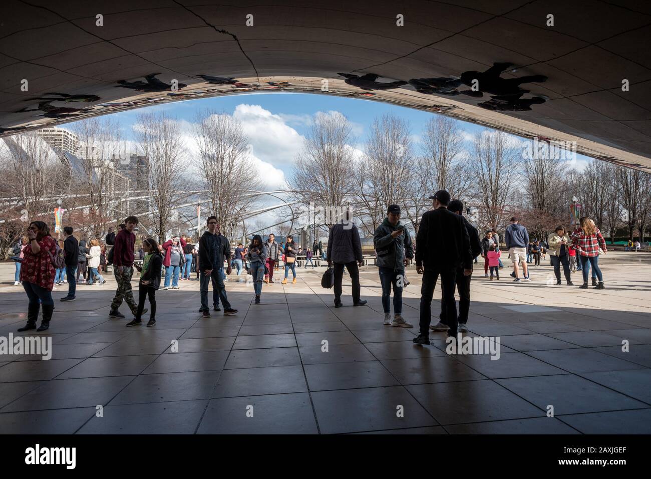 Touristen bewundern das kultige Cloud Gate im Millenium Park Anfang Frühjahr in Chicago, Illinois.Chicago ist die drittbevölkerungsreichste Stadt der USA. Stockfoto