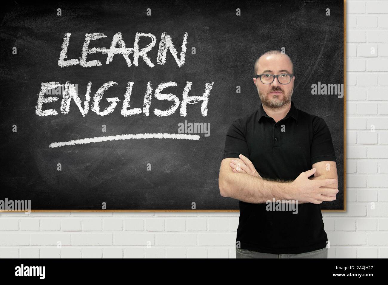 Englischlehrer in einer Sprachklasse, der den Schülern die Lektion vorstellt. Tafel und leerer Kopierbereich für den Inhalt des Editors. Stockfoto