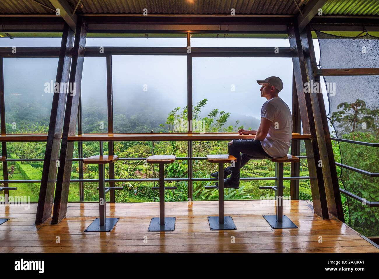 Tourist sitzt in der Lounge-Bar der Celeste Mountain Lodge in Costa Rica Stockfoto