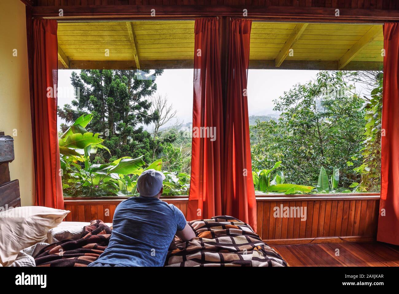 Tourist liegt auf einem Bett in Volcan Poas - Vara Blanca Tiquicia Lodge in Costa Rica Stockfoto