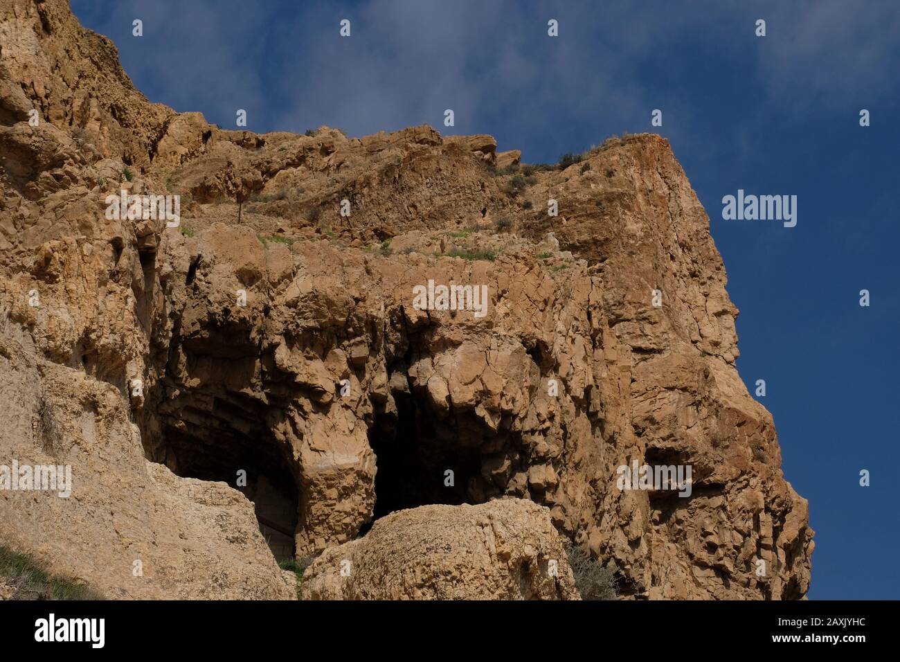 Höhlen im Berg der Versuchung, auch bekannt als Mount Quarantania und Jebel Quarantul. Beide Namen ergeben sich aus einer falschen Aussprache des lateinischen Wortes Quarentena, was 40 bedeutet, die Anzahl der Tage in der schnellen Lage Christi entlang einer Klippe mit Blick auf die Stadt Jericho in den palästinensischen Gebieten nahe dem Jordan im Westjordanland, Israel Stockfoto