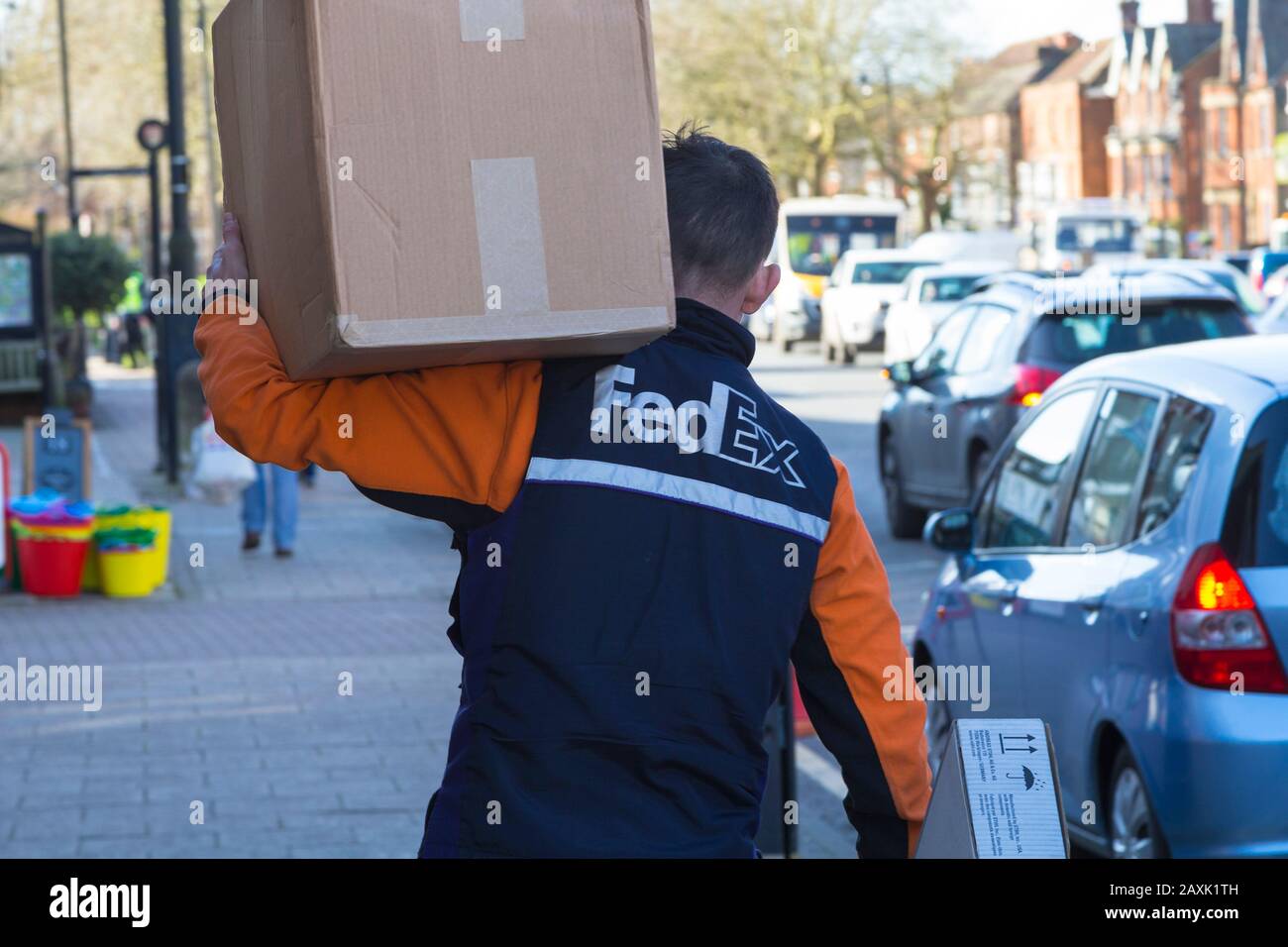 FedEx Mitarbeiter mit großer Box an der Schulter, tenterden, kent, Großbritannien Stockfoto