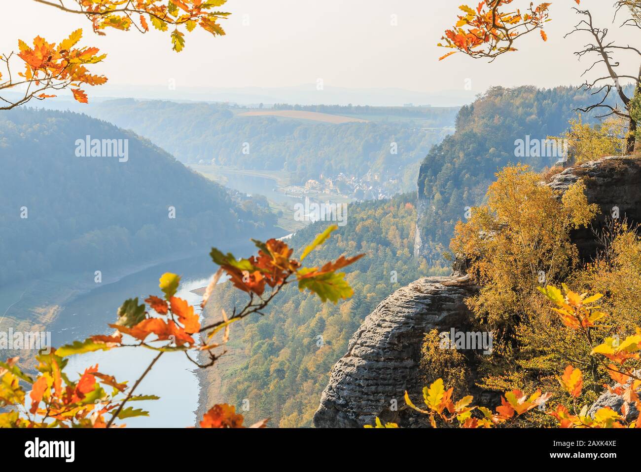 Panoramablick auf das Elbtal. Flusslauf mit Sonne und Bäumen im Herbst in der Sächsischen Schweiz. Felsen und Gebäude bei Tageslicht in den Bergen Stockfoto