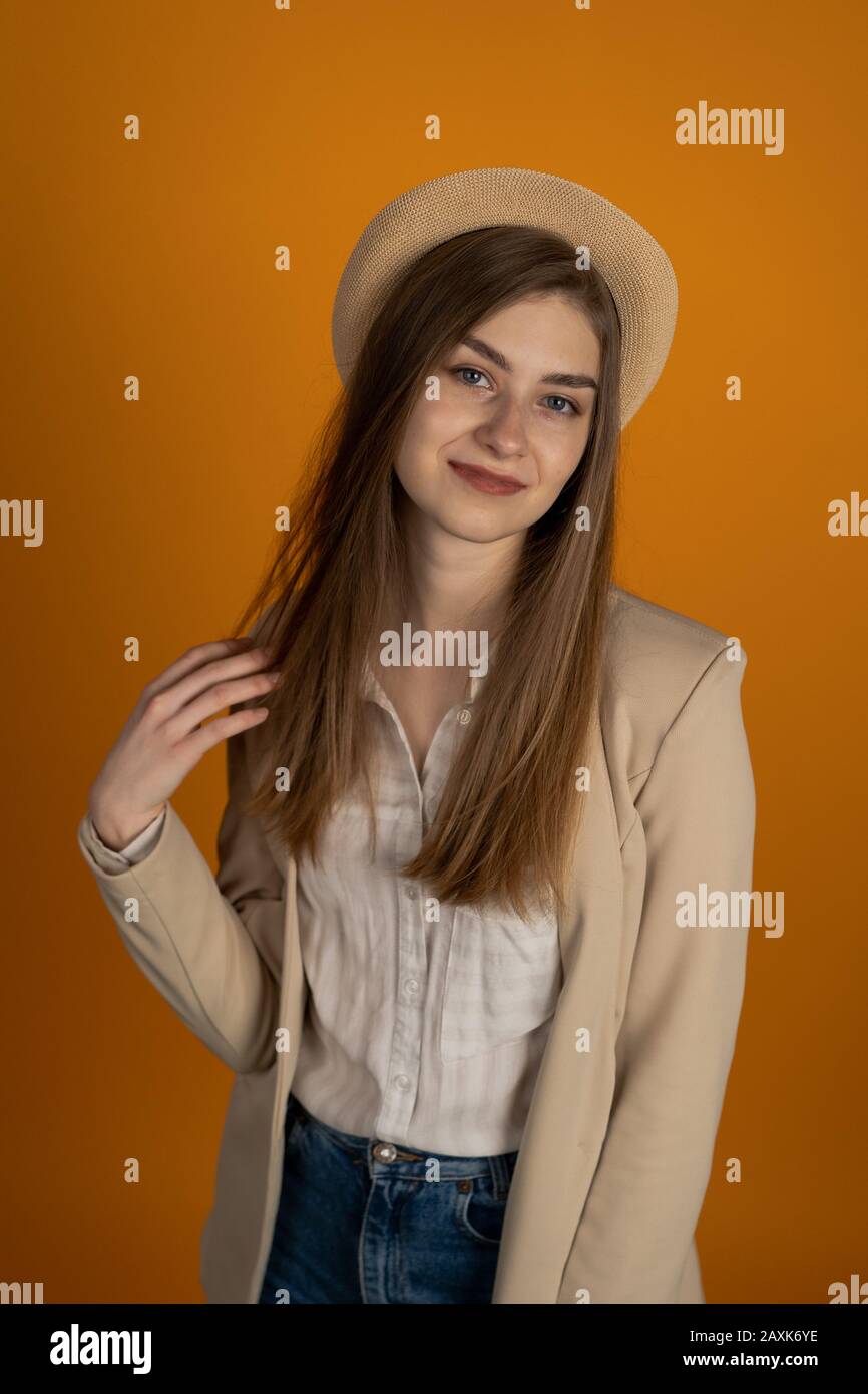Lächelnde junge Frau in Hut isoliert auf gelbem Hintergrund. Stockfoto