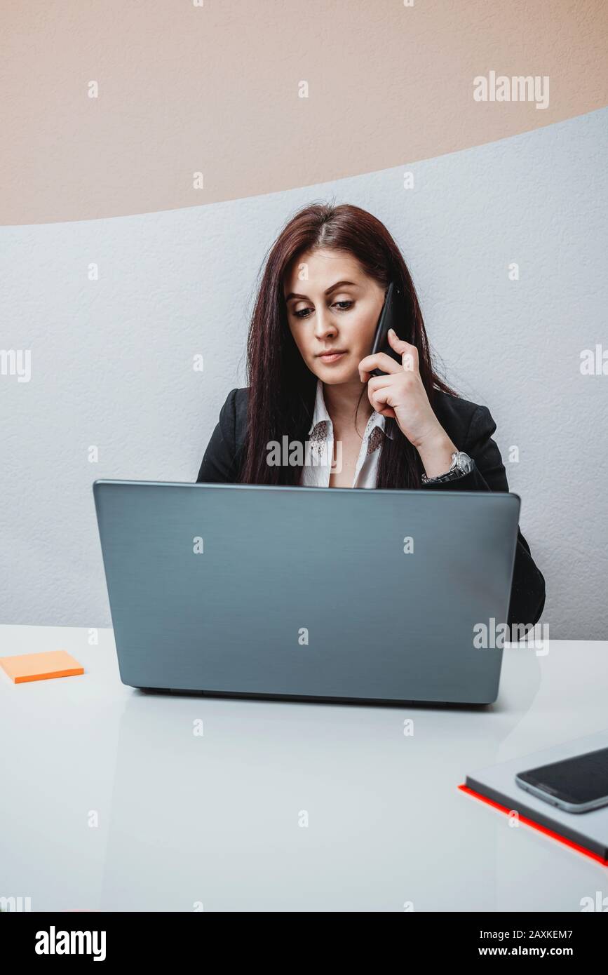 Weiblicher Chef spricht im Büro am Telefon Stockfoto