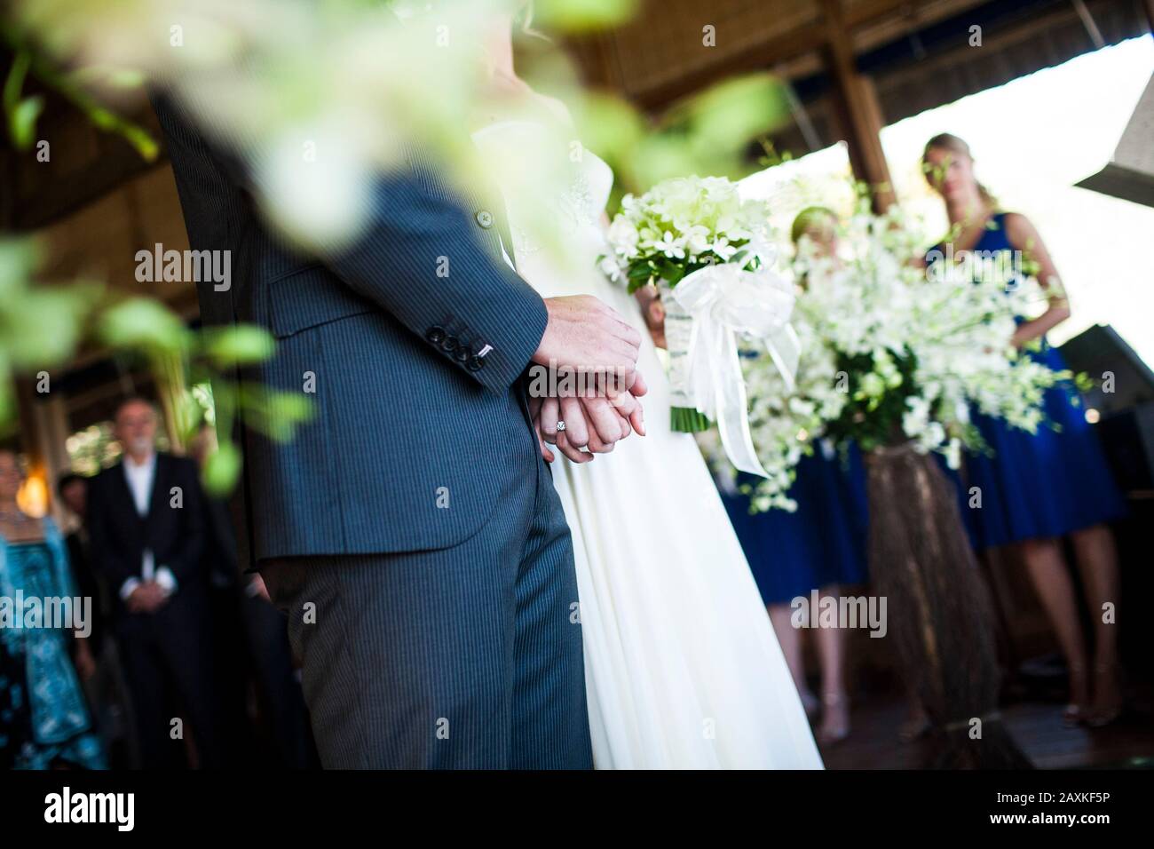 Nahaufnahme von Brautpaar und Bräutigam, die bei einer Hochzeitsfeier die Hände halten. Stockfoto