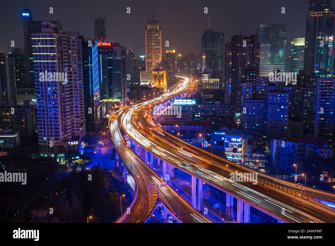 Erhöhter Blick auf gestapelte Straßenkreuzung und Skyline von Shanghai in der Abenddämmerung, Shanghai, China Stockfoto