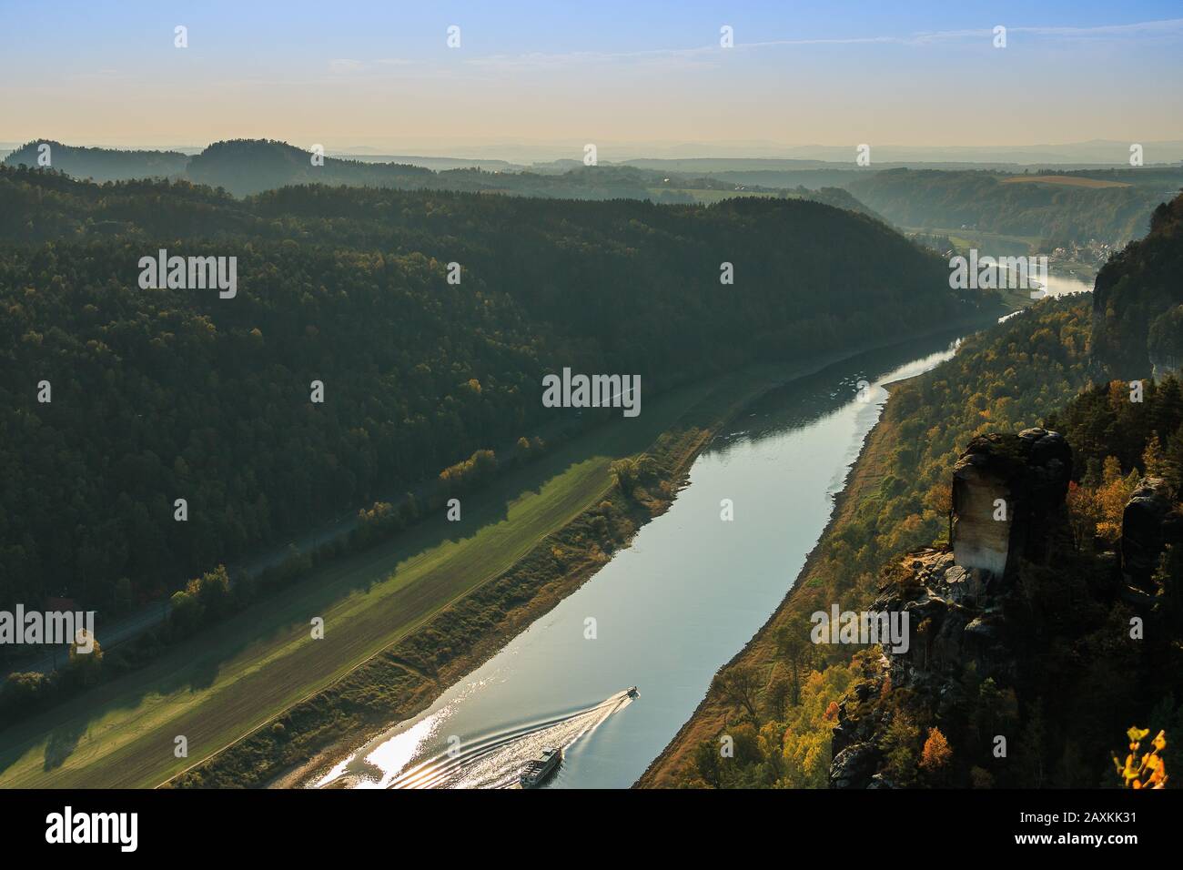 Elbe im Nationalpark Sächsische Schweiz in Herbststimmung. Felsen mit Steinen und Wäldern in der Sonne. Boot auf dem Fluss im Elbtal Stockfoto