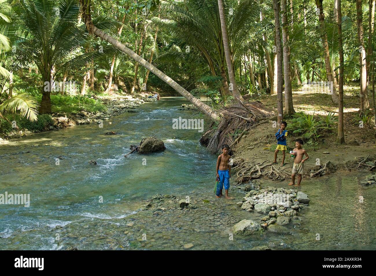 Lokale Kinder spielen an einem Strom im Dschungel, Cebu, Philippinen Stockfoto