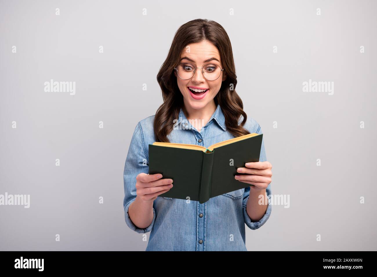 Foto von ziemlich lustigen Business Lady halten Buch Hände süchtig Leser Buch Wurm erstaunlich aufregend Happy End tragen Specs Casual Jeans Denim Shirt Stockfoto