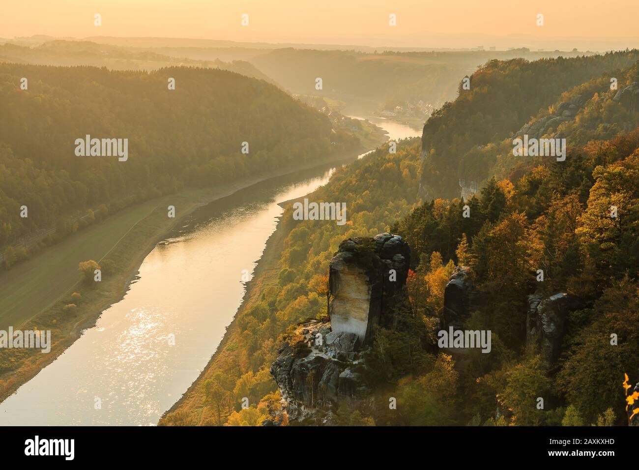 Flusslauf der Elbe in der Sächsischen Schweiz im Herbst. Felsen mit Steinen und Wäldern in der Sonne. Sonnenuntergang am Horizont über dem Elbtal. Stockfoto