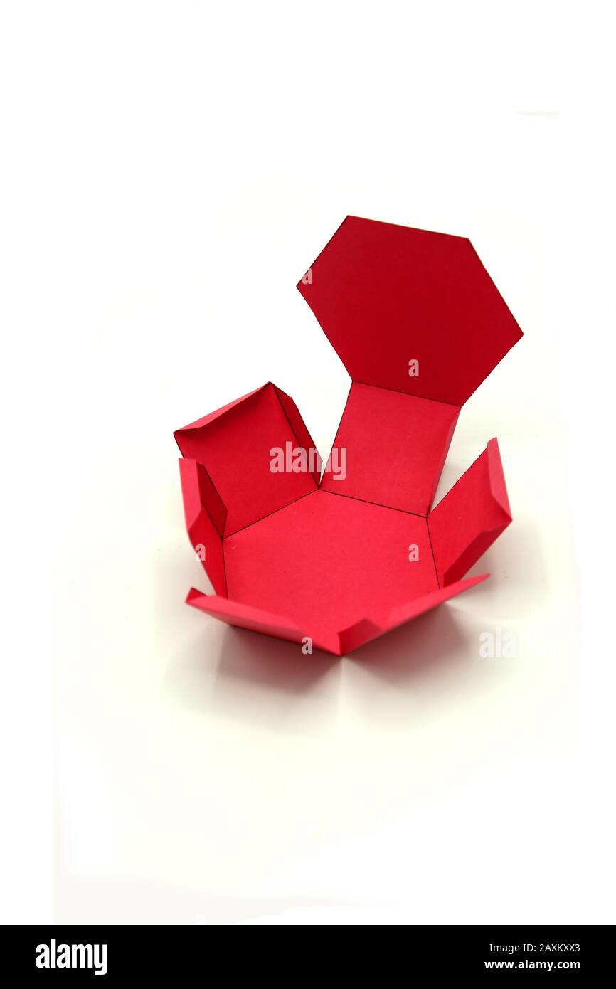 Geometrische Form aus Papier geschnitten und auf grauem Hintergrund fotografiert.Geometrienetz aus Sechseckigem Prisma. 2-dimensionale Form, die zu einem gefaltet werden kann Stockfoto