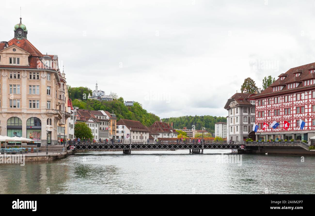 Luzerner, Schweiz - 7. Mai 2017: Stadtbild von Luzerner Stadt, Menschen gehen die Brücke in der Nähe von Luxushotels an der Flussküste von Reuss Stockfoto