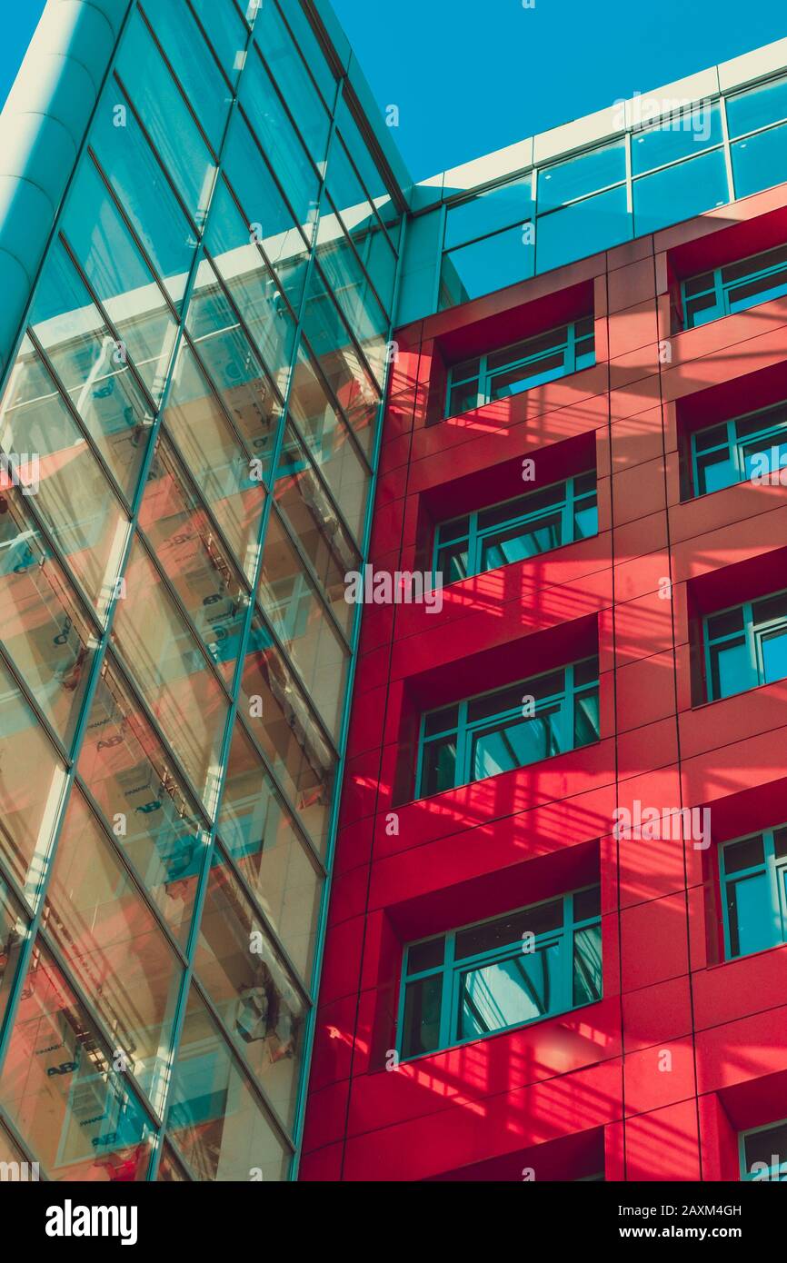 Modernes Hochhaus im High-Tech-Stil mit roten Wänden, quadratischen Fenstern und transparentem Teilefilter Stockfoto
